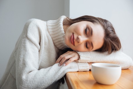 Girl in sweater near the window. sliping. with tea.の写真素材