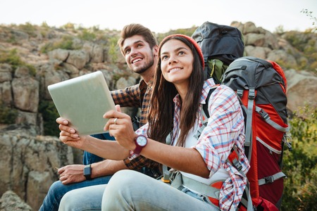 Tourist couple with tablet near the canyon. looking up.の写真素材
