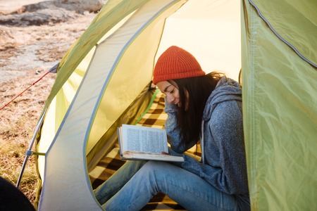 Woman with book in tent. cropped image.の写真素材