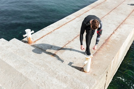 Top view of runner near the sea. tying shoelaces. preparingの写真素材