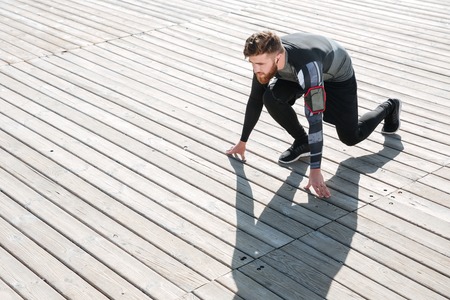 Top view of runner preparing near the sea. looking away