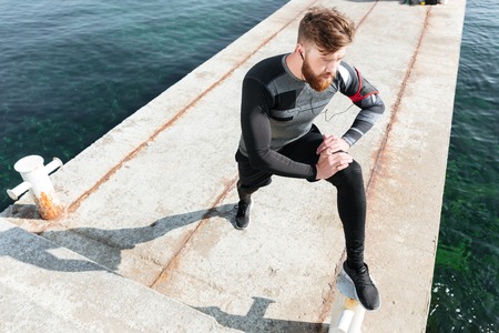 Sportsman warming up near the sea. from above.の写真素材