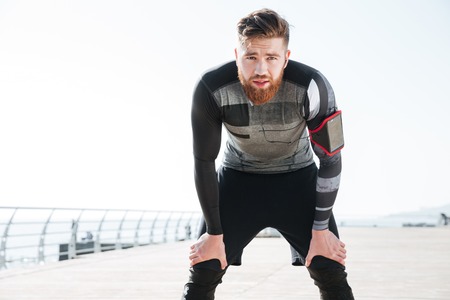 Tired runner near the sea. looking at camera. front viewの写真素材