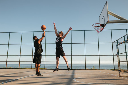 Two sportsmen playing basketball at the playgroudの写真素材