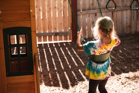Top view of girl on swing on playground. back viewの写真素材