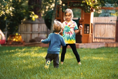 Young children on playground. playing on the grass.の写真素材