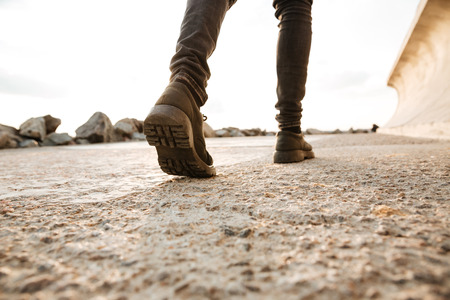 Cropped picture of young african man walking on the beach.の写真素材