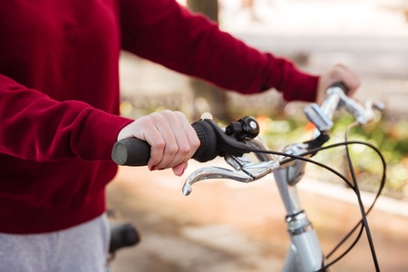 Cropped picture of young lady walking with her bicycle in the streetの写真素材