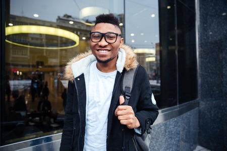 Portrait of a cheerful african young man walking on the street. Looking at camera.の写真素材