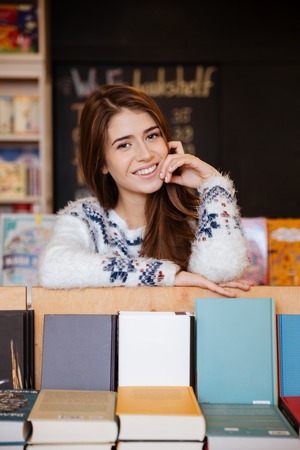 Portrait of a smiling young female student at the libraryの写真素材