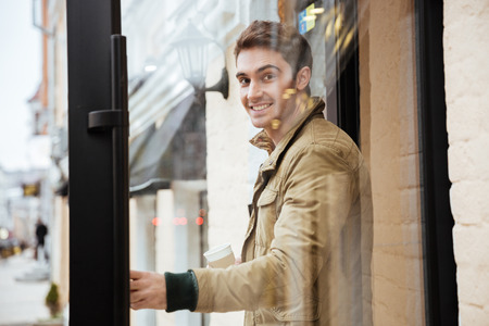 Picture of cheerful young man walking on the street and looking at camera.の写真素材