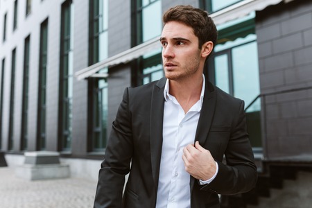 Business man in suit outdoors looking asideの写真素材