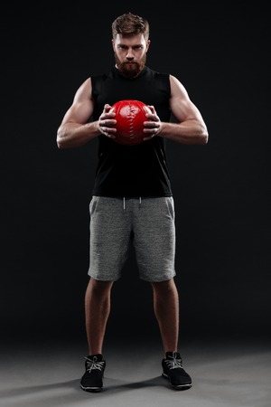 Full length image of trainer with ball. holding ball in handsの写真素材