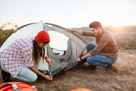 Young active couple setting up a tent outdoorsの写真素材