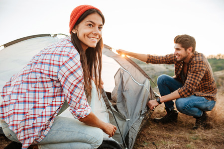 Young happy couple setting up a tent outdoorsの写真素材
