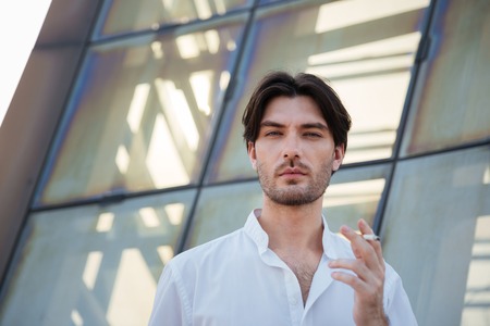 Businessman in city with cigarette. looking at the cameraの写真素材