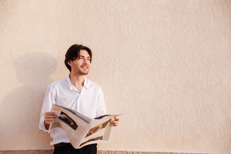 Confident young businessman reading newspaper. looking awayの写真素材