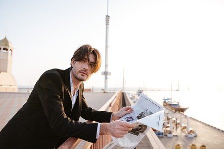 Businessman stood reading the newspaper in portの写真素材