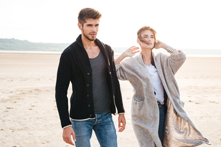 Portrait of a romantic young couple walking on the seaside in autumnの写真素材