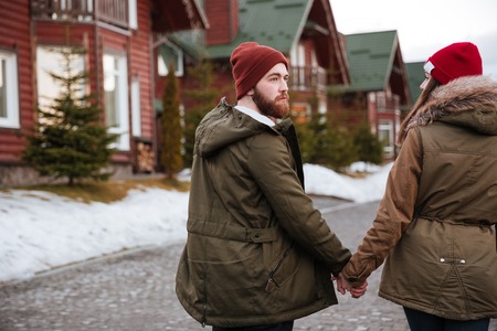 Photo of young happy loving couple walking over mountains and looking aside.の写真素材