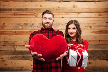 Couple with gift and heart. wooden backgroundの写真素材