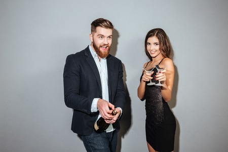 Happy friends with champagne. open champage. gray backgroundの写真素材