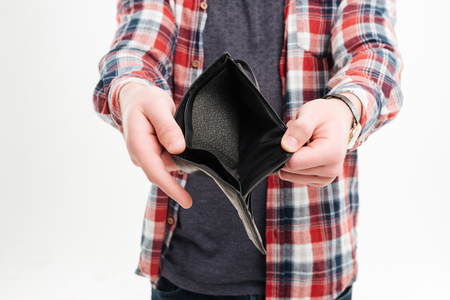Closeup image of a man in plaid shirt holding emty wallet over white background