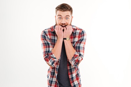Scared bearded man worrying about something and holding hands at his face isolated on a white...