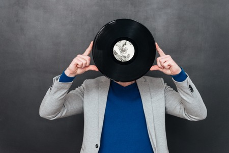 Model with vynil. hid behind vynil. isolated black backgroundの写真素材