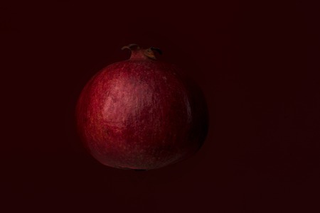 Ripe pomegranate fruit isolated on red backgroundの写真素材