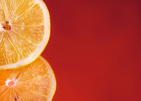 Cropped image of two orange slices isolated on red backgroundの写真素材