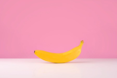 Fresh banana on table isolated over pink backgroundの写真素材