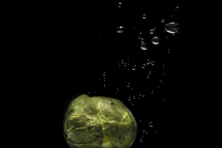 Close up of brussel cabbage with water drops isolated on black backgroundの写真素材