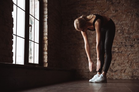 Full lenght photo of attractive young fitness woman make sport exercises in gym.の写真素材