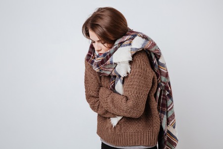 Pretty Freeze woman in sweater and scarf. Isolated gray backgroundの写真素材