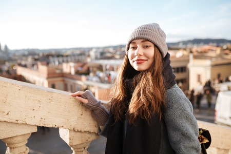 Happy attractive young woman walking in old city in springの写真素材