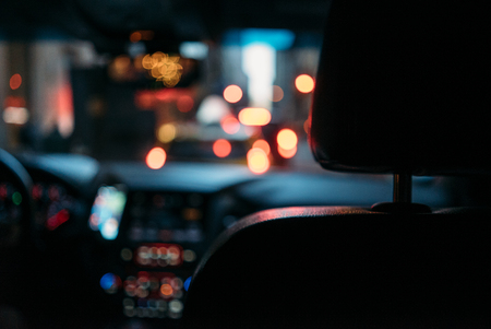 Night road view from inside car with natural light street and other cars in motion blurred
