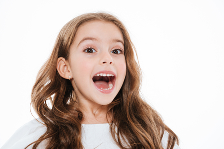 Cheerful charming little girl smiling and laughing over white backgroundの写真素材