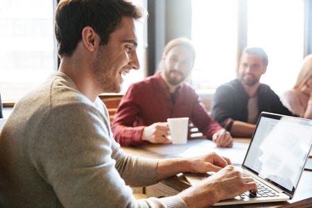 Image of young happy colleagues sitting in office and coworking.の写真素材