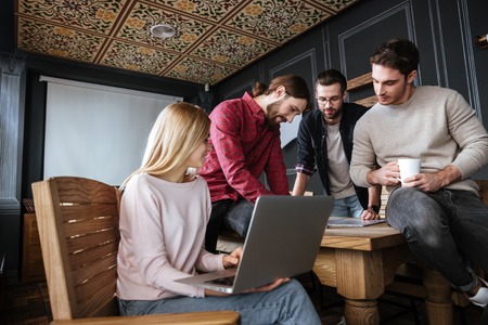 Photo of young attractive colleagues standing in office and coworking.