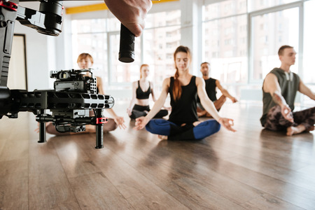 Video shooting of people doing yoga and meditating in studio. Backstageの写真素材