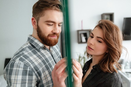 Photo of attractive young quarel loving couple standing at home indoors. Looking aside.の写真素材