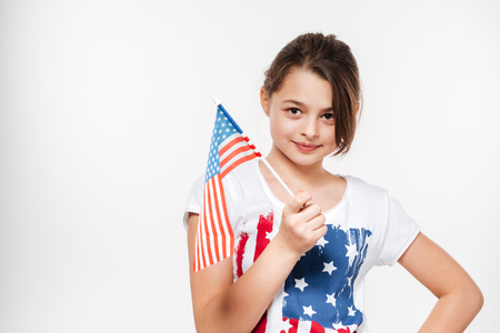 Image of happy young girl holding USA flag posing isolated over white background.の写真素材