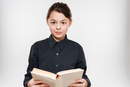 Image of cheerful young girl reading book isolated over white background.の写真素材