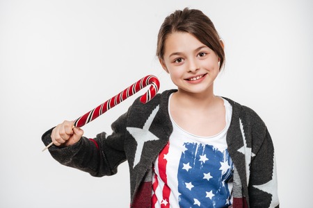 Picture of cheerful young girl posing with candy isolated over white background.の写真素材