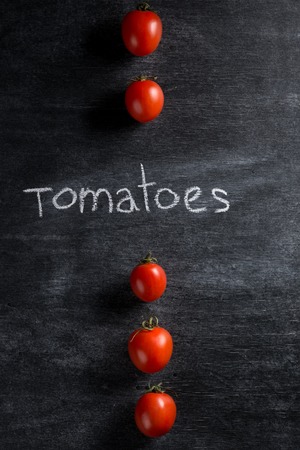 Top view picture of a lot of tomatoes over dark backgroundの写真素材