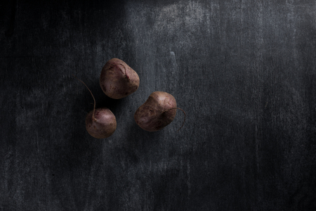 Top view photo of a beet over dark chalkboard backgroundの写真素材