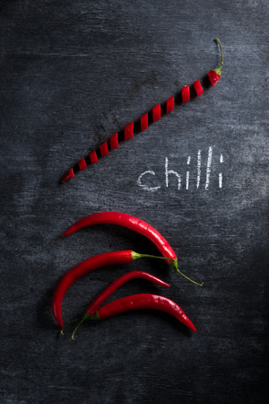 Top view image of a lot of cut chilli pepper over dark background.の写真素材