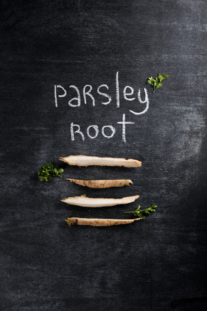 Top view image of parsley root over dark chalkboard background.の写真素材