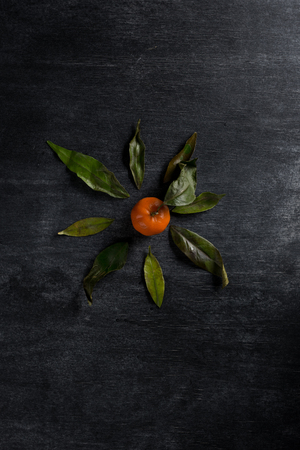 Top view photo of tangerine over dark chalkboard backgroundの写真素材